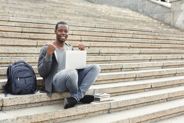 Ευτυχισμένος επιτυχής φοιτητής που κάθονται στα σκαλοπάτια που χρησιμοποιούν φορητό υπολογιστή — Φωτογραφία Αρχείου