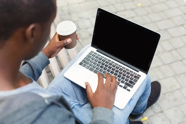 Αρσενικό χέρια με laptop και καφέ closeup, πάνω από τον ώμο γυρίστηκε σε εξωτερικούς χώρους — Φωτογραφία Αρχείου