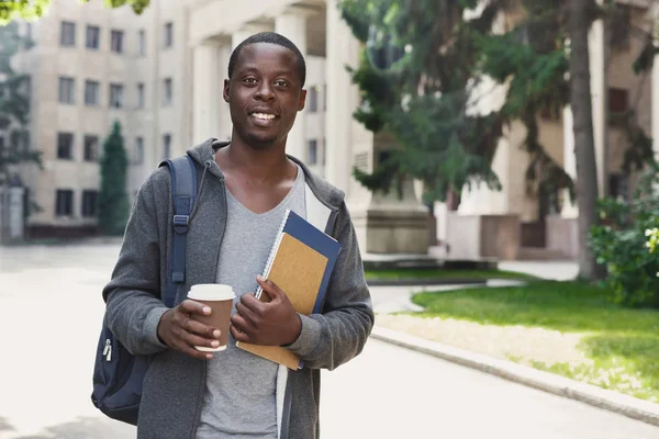 Estudante afro-americano com livros no campus universitário ao ar livre — Fotografia de Stock