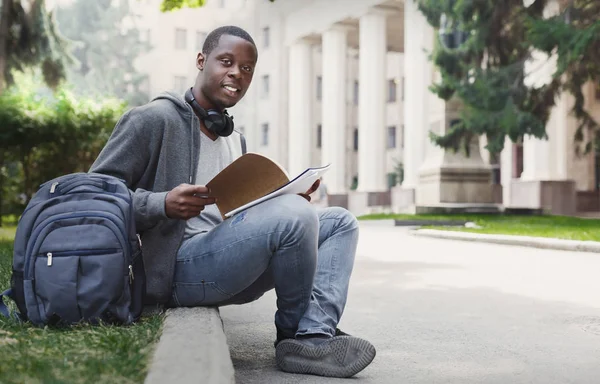 Estudante afro-americano sentado com notebook no campus universitário — Fotografia de Stock