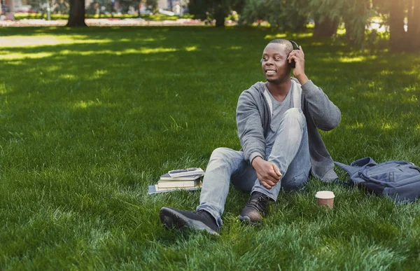 S úsměvem afroamerické studentů poslechu hudby v parku venku — Stock fotografie