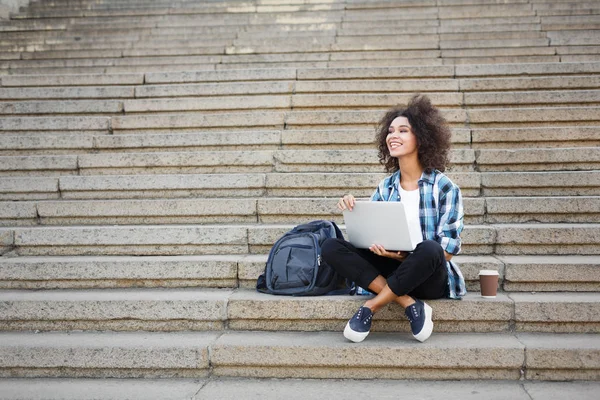 Mosolygó diák ül a lépcsőn használ laptop — Stock Fotó