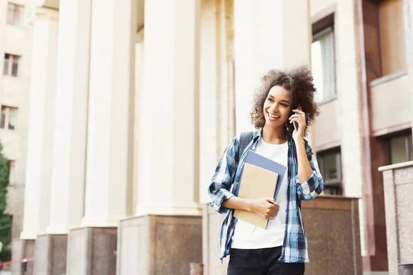 Studentjente med ryggsekk og mobil på universitetsbyggende bakgrunn – stockfoto