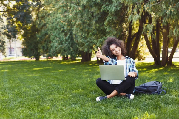 Glad ung kvinna med laptop i park — Stockfoto