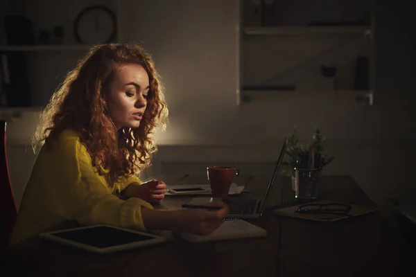 Donna concentrata prendere appunti a casa la sera — Foto Stock