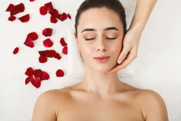 Mujer recibiendo masaje facial profesional en salón de belleza —  Fotos de Stock