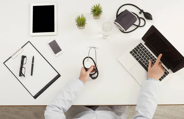 Doctor sitting at office desk, top view — Stock Photo, Image