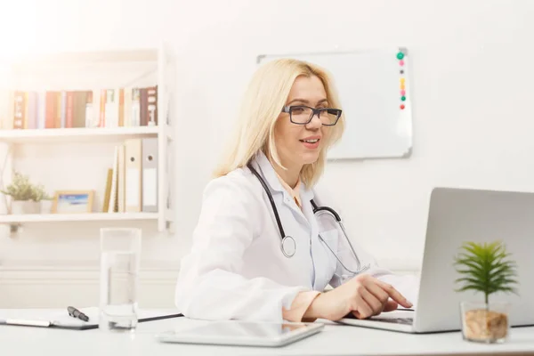 デスクトップで座っている女性医師の肖像画 — ストック写真