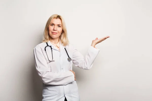 Mujer farmacéutica apuntando sobre fondo blanco —  Fotos de Stock