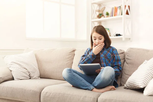 Young shocked girl with digital tablet at home — Stock Photo, Image