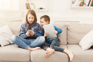 Becerikli evde kanepede iki çocuklu