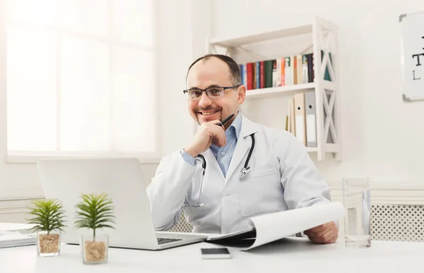 Glücklicher Arzt sitzt in seinem Büro — Stockfoto