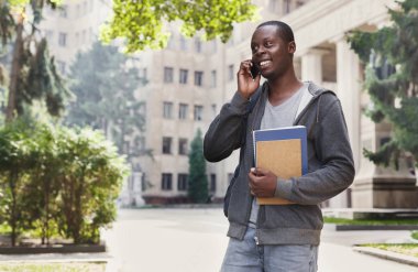 Kampüs içinde smartphone cep telefonu ile konuşmak mutlu Afrikalı-Amerikalı öğrenci