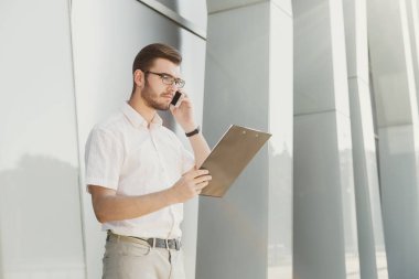 Genç işadamı açık havada belgelerle çalışma