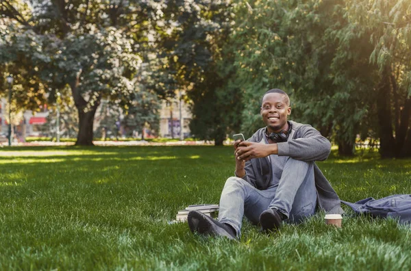 Souriant étudiant afro-américain utilisant le téléphone en plein air — Photo