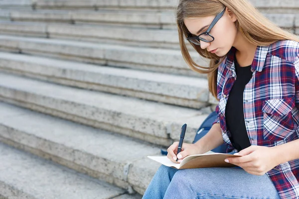 Jovem estudante fazendo anotações no caderno — Fotografia de Stock