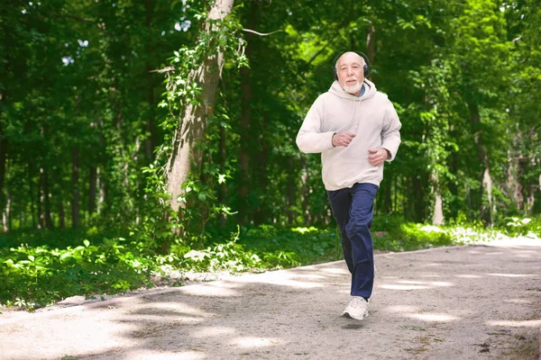 Hombre mayor corriendo en el bosque verde, espacio para copiar —  Fotos de Stock