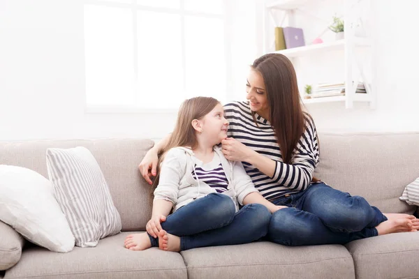 Moeder met haar schattig dochtertje zittend op de Bank. — Stockfoto