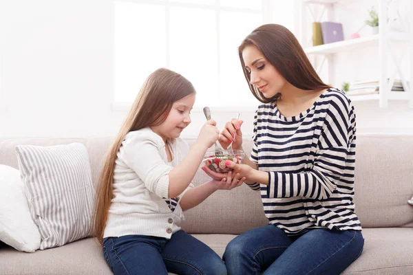 Niña y su mamá comiendo una ensalada en casa —  Fotos de Stock