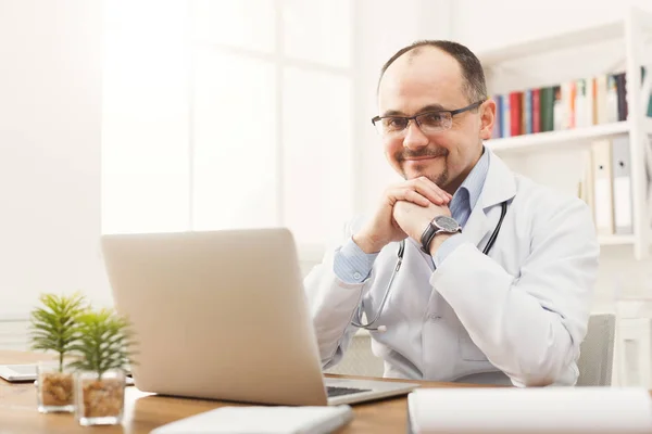 Portrait of doctor in glasses sitting at the desktop — Stock Photo, Image