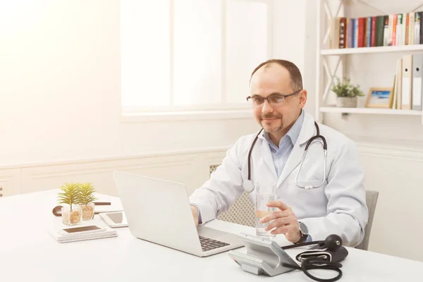 Portrait of doctor in glasses sitting at the desktop — Stock Photo, Image