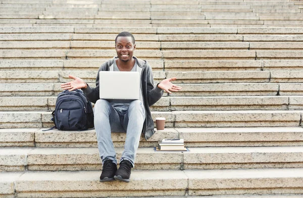 Sorprendida estudiante afroamericana sentada en escaleras usando laptop — Foto de Stock