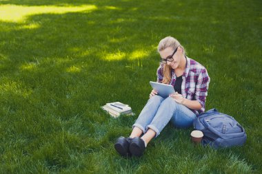 Mutlu genç kadın parkta dijital tablet kullanma