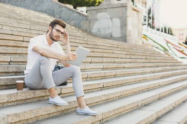 Dalgın işadamı açık havada tablet ile çalışma