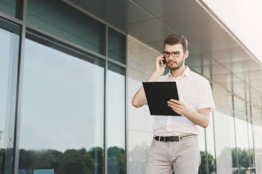 Genç işadamı açık havada belgelerle çalışma