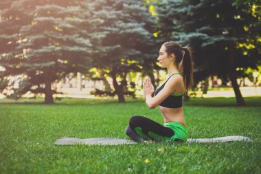 Pratik yoga padmasana içinde oturan genç çekici kadın