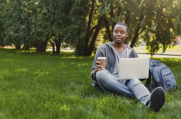 Σοβαρές Αφρικανικός-Αμερικανός φοιτητής που χρησιμοποιούν φορητό υπολογιστή στο πάρκο — Φωτογραφία Αρχείου