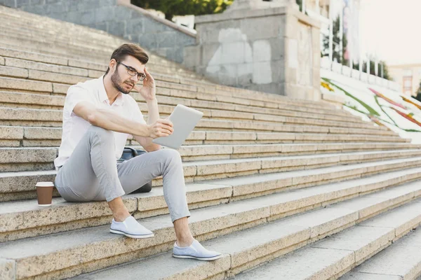 Hombre de negocios pensativo trabajando con la tableta al aire libre — Foto de Stock