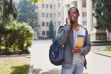 Kampüs içinde smartphone cep telefonu ile konuşmak mutlu Afrikalı-Amerikalı öğrenci