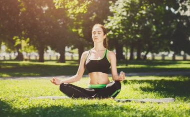 Genç kadın açık havada, sakin ol meditasyon poz