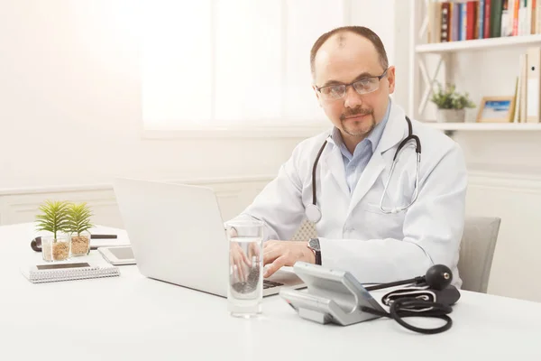 デスクトップに座ってメガネの医師の肖像画 — ストック写真