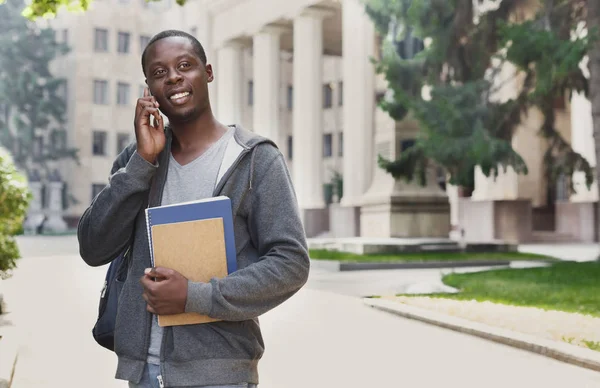 Happy afroamerické student mluvil na smartphone v areálu — Stock fotografie