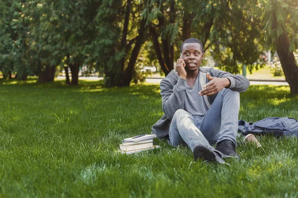 Estudiante afroamericano hablando por teléfono en el campus universitario —  Fotos de Stock