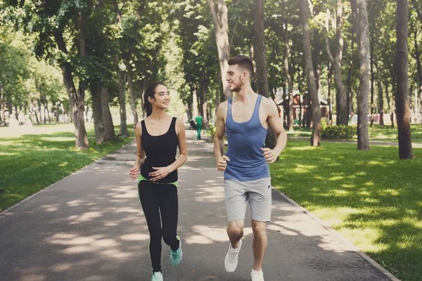 年轻夫妇在绿色公园慢跑, 复制空间 — 图库照片