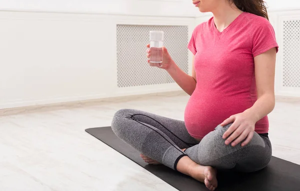 Kobieta w ciąży wody pitnej w domu — Zdjęcie stockowe