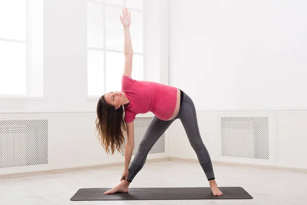 Gravid kvinna stretching händer och ben — Stockfoto