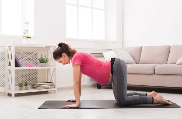 Junge schwangere Frau praktiziert Yoga zu Hause — Stockfoto