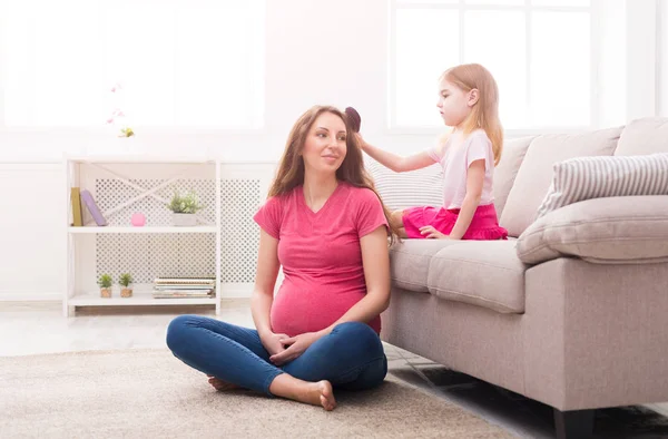 Daughter combing her mothers hair at home — Stock Photo, Image