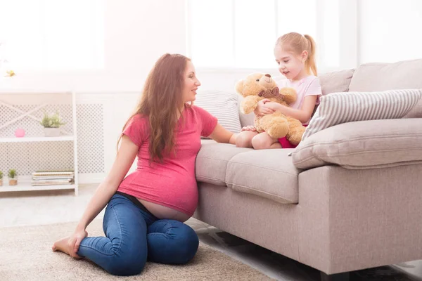 Mother with her little daughter sitting on sofa — Stock Photo, Image