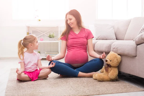 Madre e hija pequeña practicando yoga en casa —  Fotos de Stock