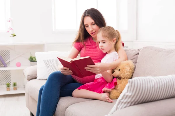 Dziewczynka i jej Mama, czytanie książki w domu — Zdjęcie stockowe