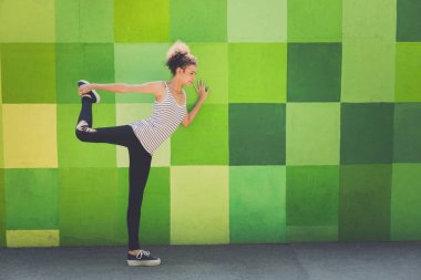 Genç bayan koşucu koşmadan önce ısınıyor.