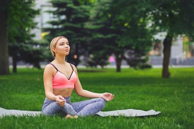 Genç kadın açık havada, sakin ol meditasyon poz