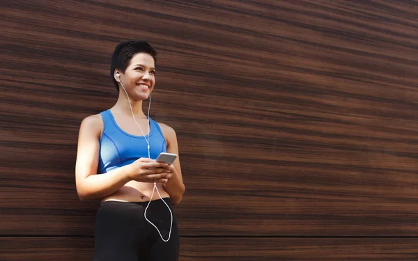 Mujer elegir la música para escuchar durante el entrenamiento —  Fotos de Stock