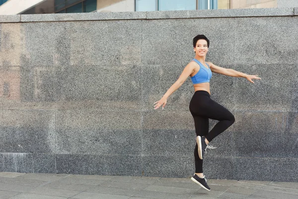 Hermosa joven bailando contra la pared de ladrillo — Foto de Stock