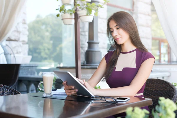 Café'de dijital tablet ile çalışan genç kadın — Stok fotoğraf